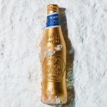 A limited-edition gold bottle for Peroni Nastro Azzurro lying in the snow