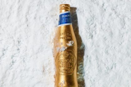 A limited-edition gold bottle for Peroni Nastro Azzurro lying in the snow