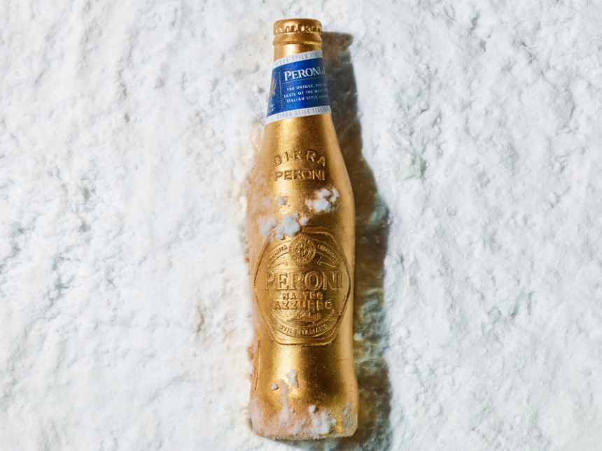 A limited-edition gold bottle for Peroni Nastro Azzurro lying in the snow