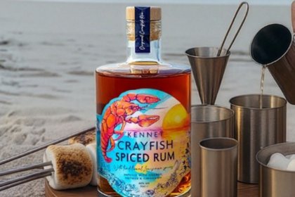 Bottle of rum on a table outside with barbecue accessories