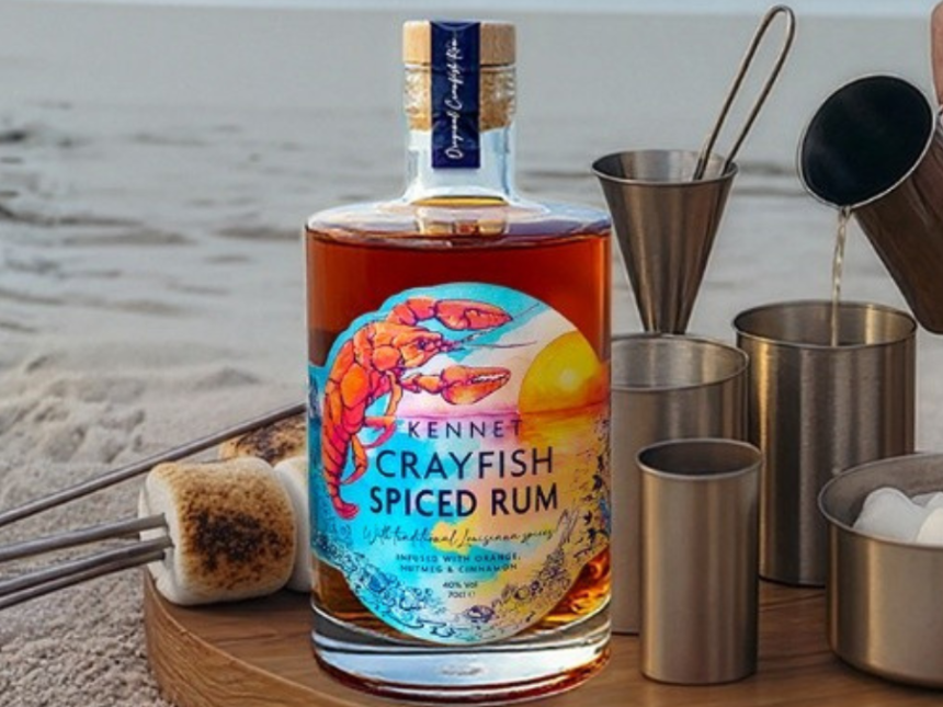 Bottle of rum on a table outside with barbecue accessories