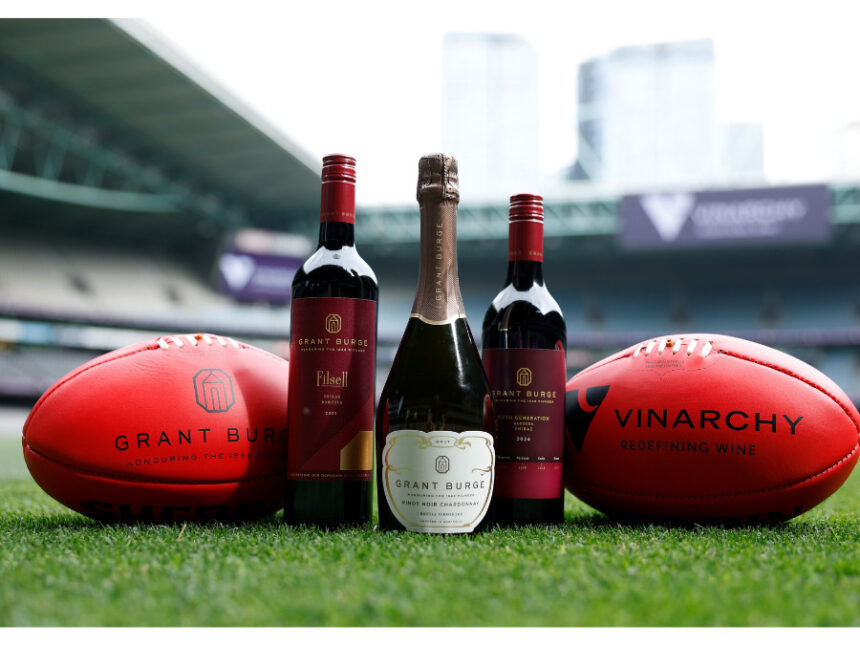Grant Burge bottles with two Australian footballs