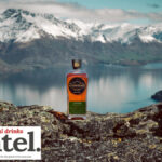 Scapegrace whisky bottle against lake and mountain backdrop