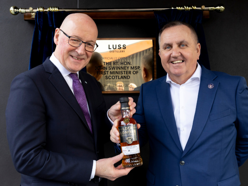 First Minister John Swinney Opens Luss-Distillery in Scotland, pictured with CEO Colin Matthews holding a bottle of whiskey in front of a plaque