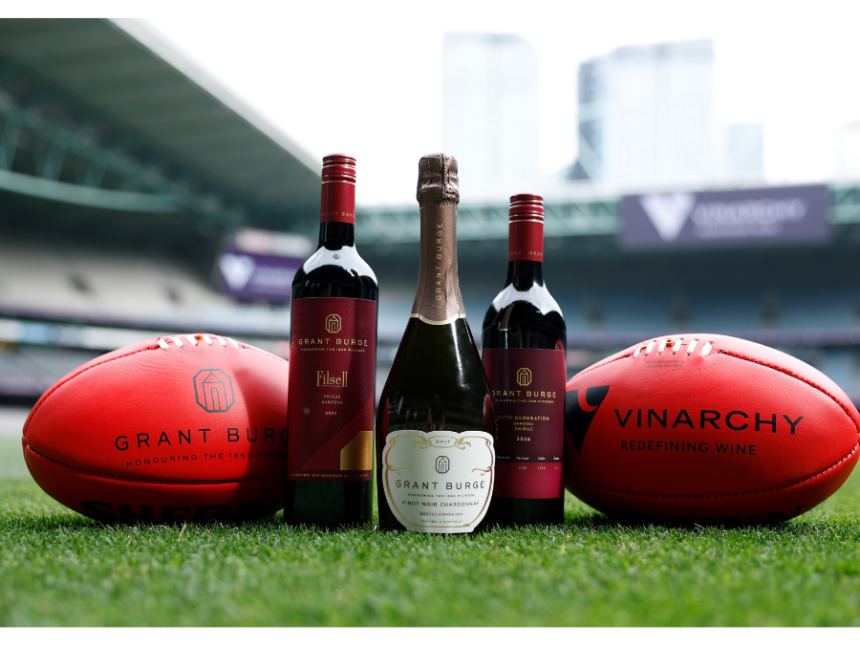 Grant Burge bottles with two Australian footballs
