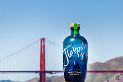 A bottle of Junipero gin in front of the golden gate bridge in San Fran