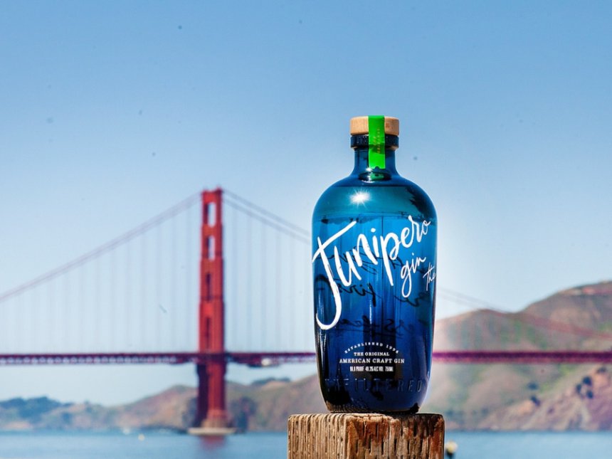 A bottle of Junipero gin in front of the golden gate bridge in San Fran