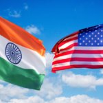 India and US flags against sky