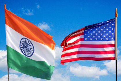 India and US flags against sky