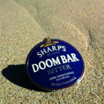 A pump clip for Doom Bar beer on the beach