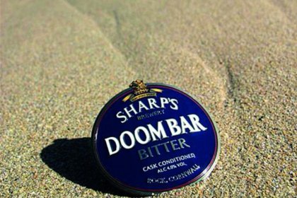 A pump clip for Doom Bar beer on the beach