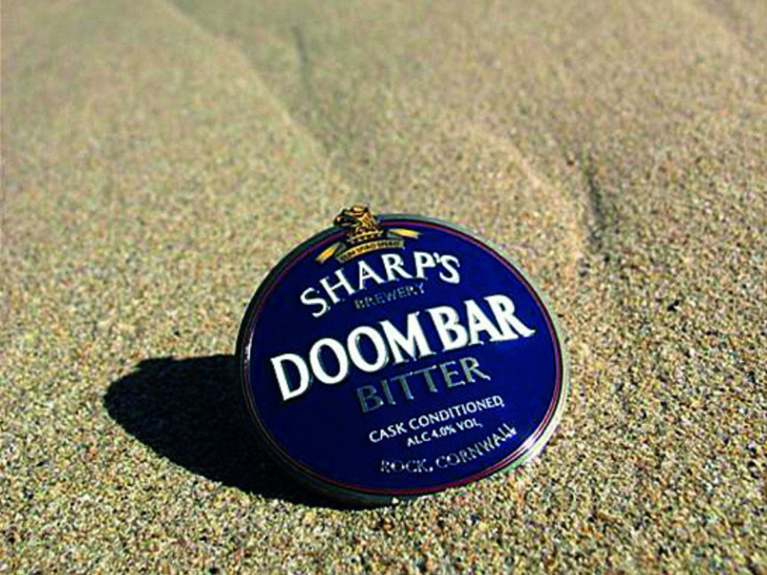 A pump clip for Doom Bar beer on the beach