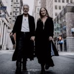 Man and woman hold hands walking down a New York street