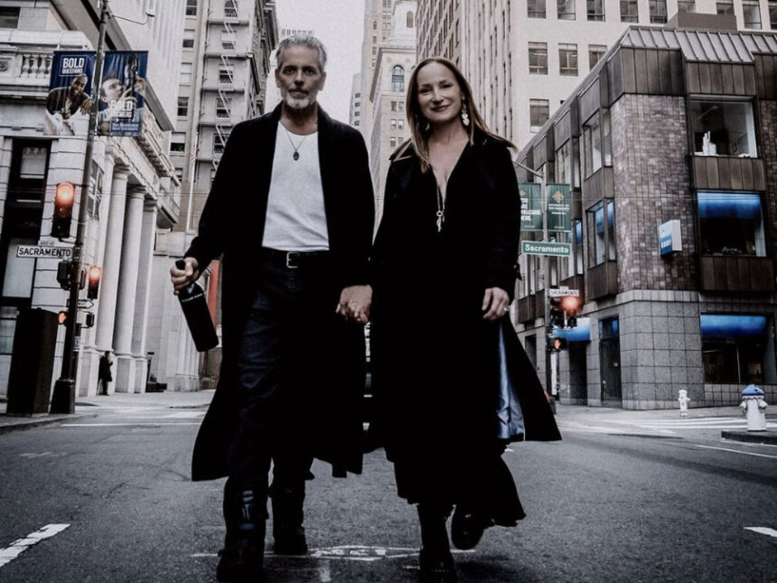 Man and woman hold hands walking down a New York street