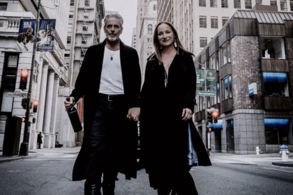 Man and woman hold hands walking down a New York street