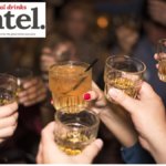 Four raised glasses in a crowd
