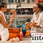 Two drinkers outside by a river with a bottle of Mionetto RTS