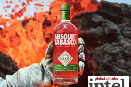 Absolute Tabasco bottle held out by a white gloved hand in front of lava