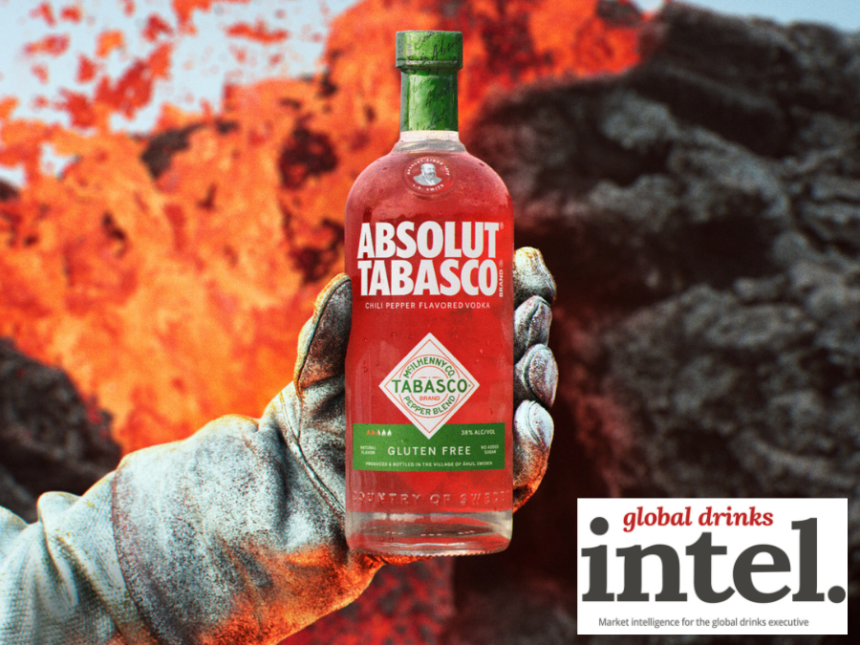Absolute Tabasco bottle held out by a white gloved hand in front of lava