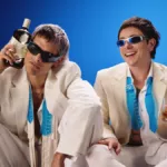 Ca7riel & Paco Amoroso with Ballantine's bottle and glass