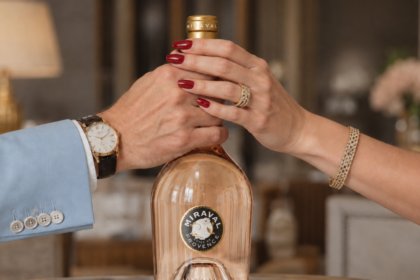 Miraval rose bottle with a male and a female's hands around the neck