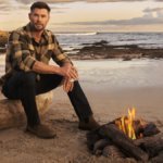 Chris Hemsworth on a beach with a glass of Archie Rose whisky