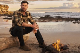 Chris Hemsworth on a beach with a glass of Archie Rose whisky