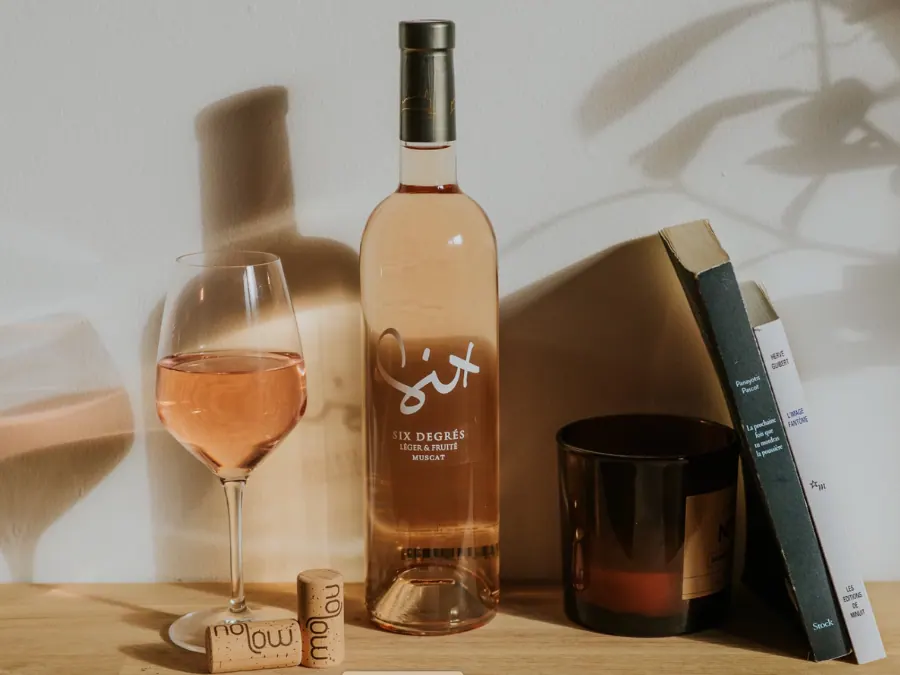 Wine bottle with glass behind two Vinventions no low closures