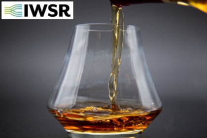 Glass of brown spirits with IWSR logo