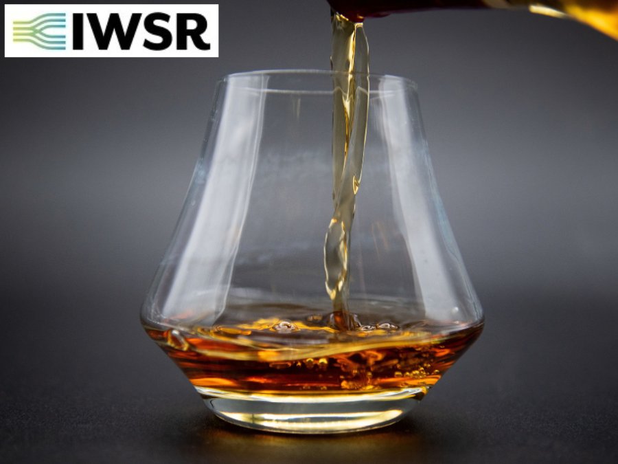 Glass of brown spirits with IWSR logo