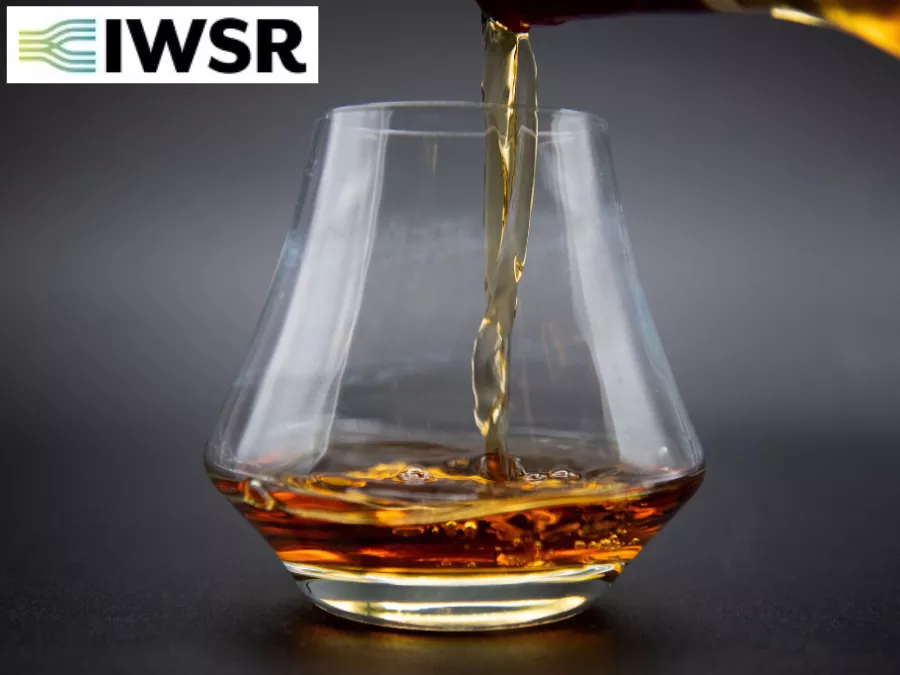 Glass of brown spirits with IWSR logo